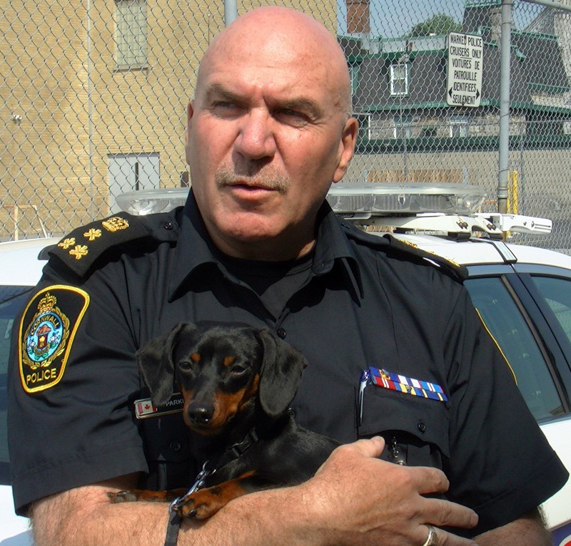 Cornwall Ontario Police Chief Dan Parkinson holding Fitzy the Dachshund.